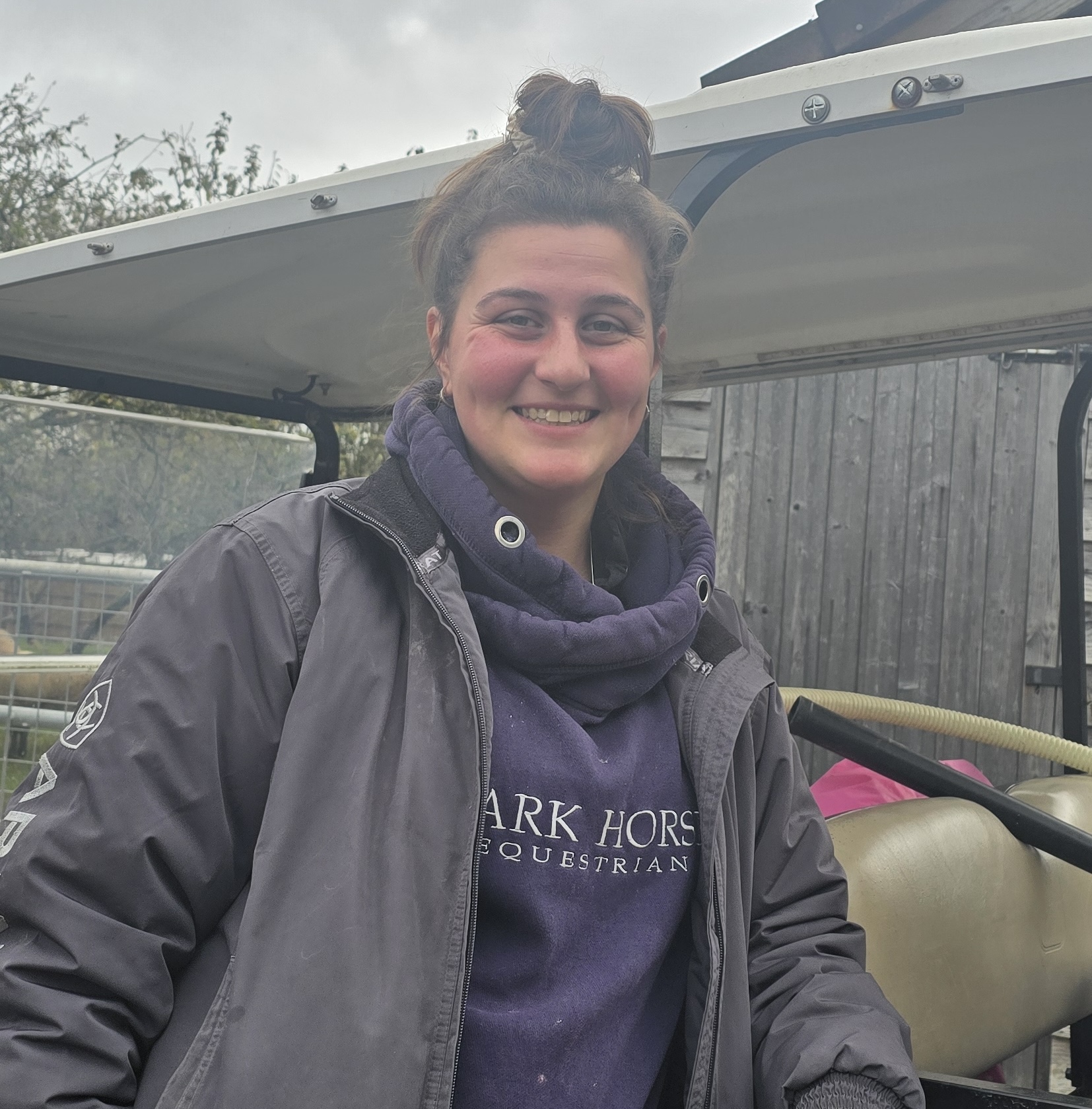 woman with brown hair in bun in front of buggy
